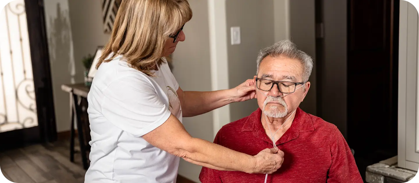 Hospice caregiver assisting an elderly patient at home